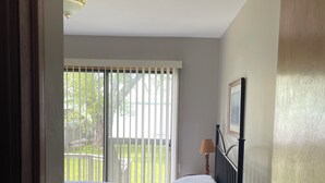 A bedroom with a bed, a bedside table with a tissue box, a lamp, and a door. - Lake Simcoe Getaway — Just 1 Hour from Toronto! Family cottage rarely offered! (Georgina)
