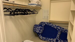 Un'area lavanderia con un cesto, un'asta appendiabiti e vestiti piegati.