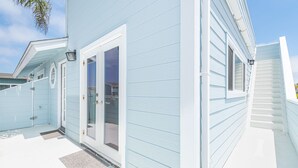 A light blue house with a white door and a small porch.