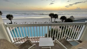 A balcony with a view of the ocean and a pool. - A breathtaking oceanfront studio w/ a private balcony (Daytona Beach)