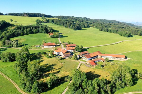 An aerial view of a rural property with multiple buildings, surrounded by green fields and forests. - Apartment "Lina" with Shared Garden, Balcony, and Wi-Fi (Rottenbuch)