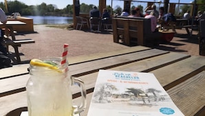 Ein Picknicktisch mit einem Getränk und einer Broschüre.