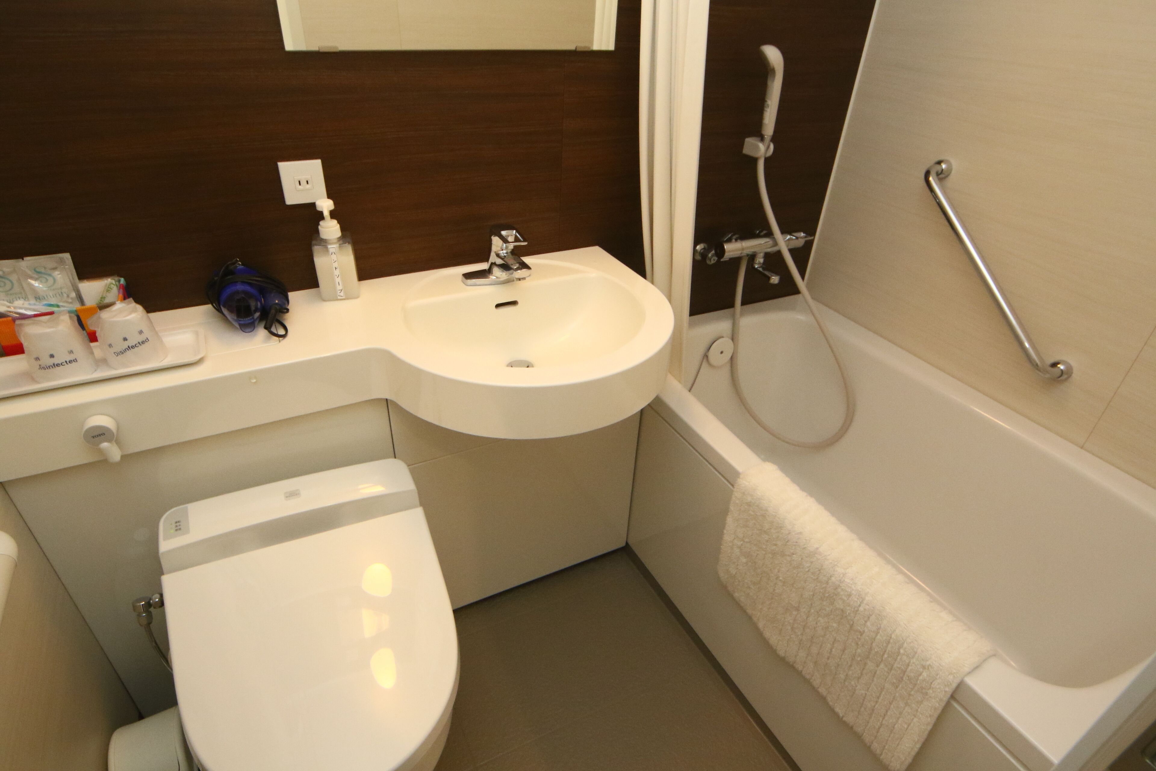 A modern bathroom with a white sink, toilet, and bathtub.