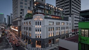 A multi-story hotel with a prominent entrance, large windows, and a rooftop terrace.