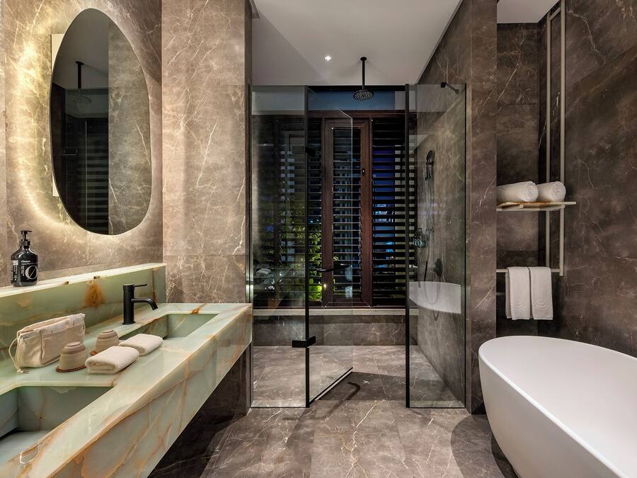 A modern bathroom with a large mirror, a glass-enclosed shower, and a bathtub.