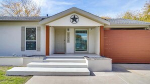 A modern house with a front porch, a garage, and a star-shaped logo above the entrance. - Walk to AT&T Stadium, Globe Life | Pickleball | Game Room (Arlington)