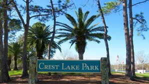 Un panneau indiquant l’entrée du parc de Crest Lake, entouré d’arbres et d’herbe.