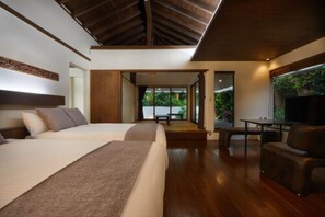 A modern hotel room with a large bed, a seating area, and a view of the outdoors. - Private Villas Ryuz BISE (Motobu)
