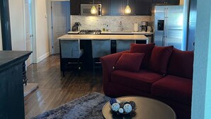 Une cuisine moderne avec des meubles de couleur sombre, un îlot central et un ventilateur de plafond.