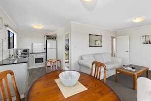 A compact living space with a kitchen, dining area, and a living room.