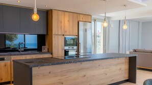Una cucina moderna con mobili in legno, un'isola centrale e luci a sospensione.