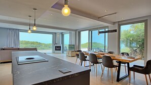 Una cucina moderna con una grande isola, zona pranzo con sedie e un camino.