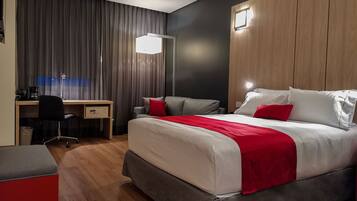 Una habitación de hotel moderna con una cama grande, un escritorio y una silla.
