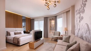 A modern hotel room with a large bed, a sofa, a TV, and a chandelier. - The Pearl Suites (Istanbul)