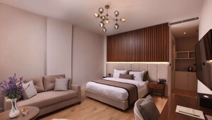 A modern hotel room with a sofa, a bed, a desk, and a television. - The Pearl Suites (Istanbul)