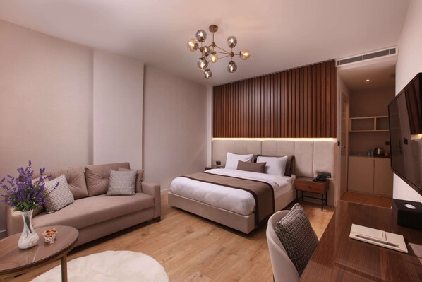 Une chambre d’hôtel moderne équipée d’un canapé, d’un lit, d’un bureau et d’une télévision.