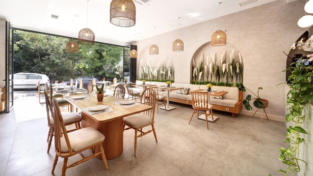 A modern dining area with wooden furniture, pendant lighting, and a view of the outdoors. - The Pearl Suites (Istanbul)
