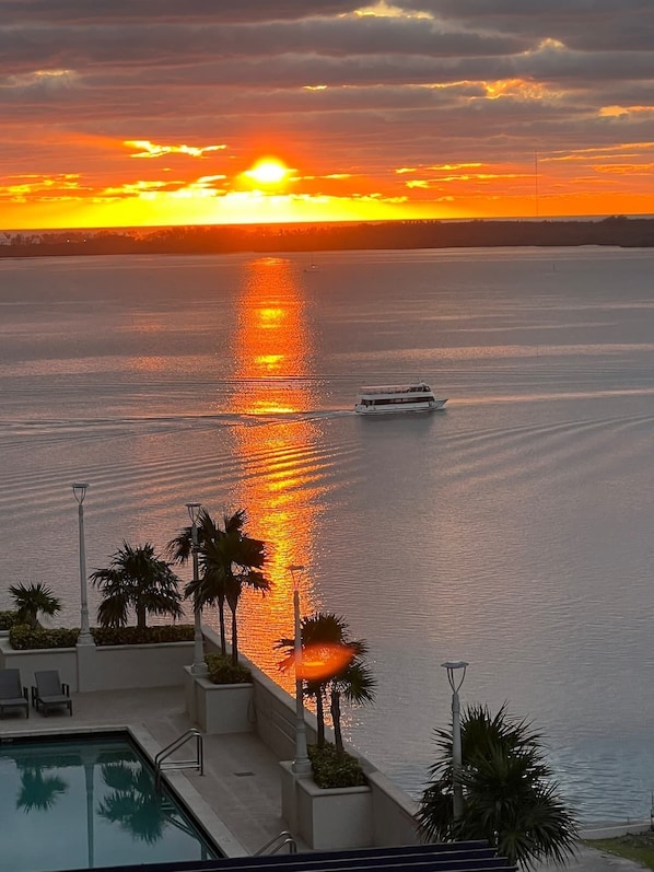Enjoy a serene waterfront setting with a tranquil body of water, a pool area, and a boat on the water.