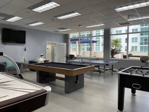 Enjoy games and entertainment in this spacious room with a pool table, foosball table, and ping pong table.