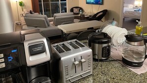 Une cuisine équipée d’une machine à café Hamilton Beach Flexbrew, d’un grille-pain, d’une bouilloire et d’un égouttoir à vaisselle.