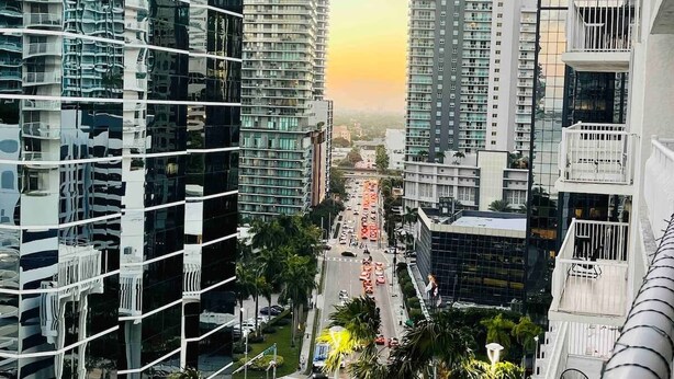 Un immeuble de grande hauteur au design moderne, doté de balcons et offrant une vue sur la rue.