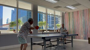 Enjoy a game of ping pong in a spacious indoor area with city views.