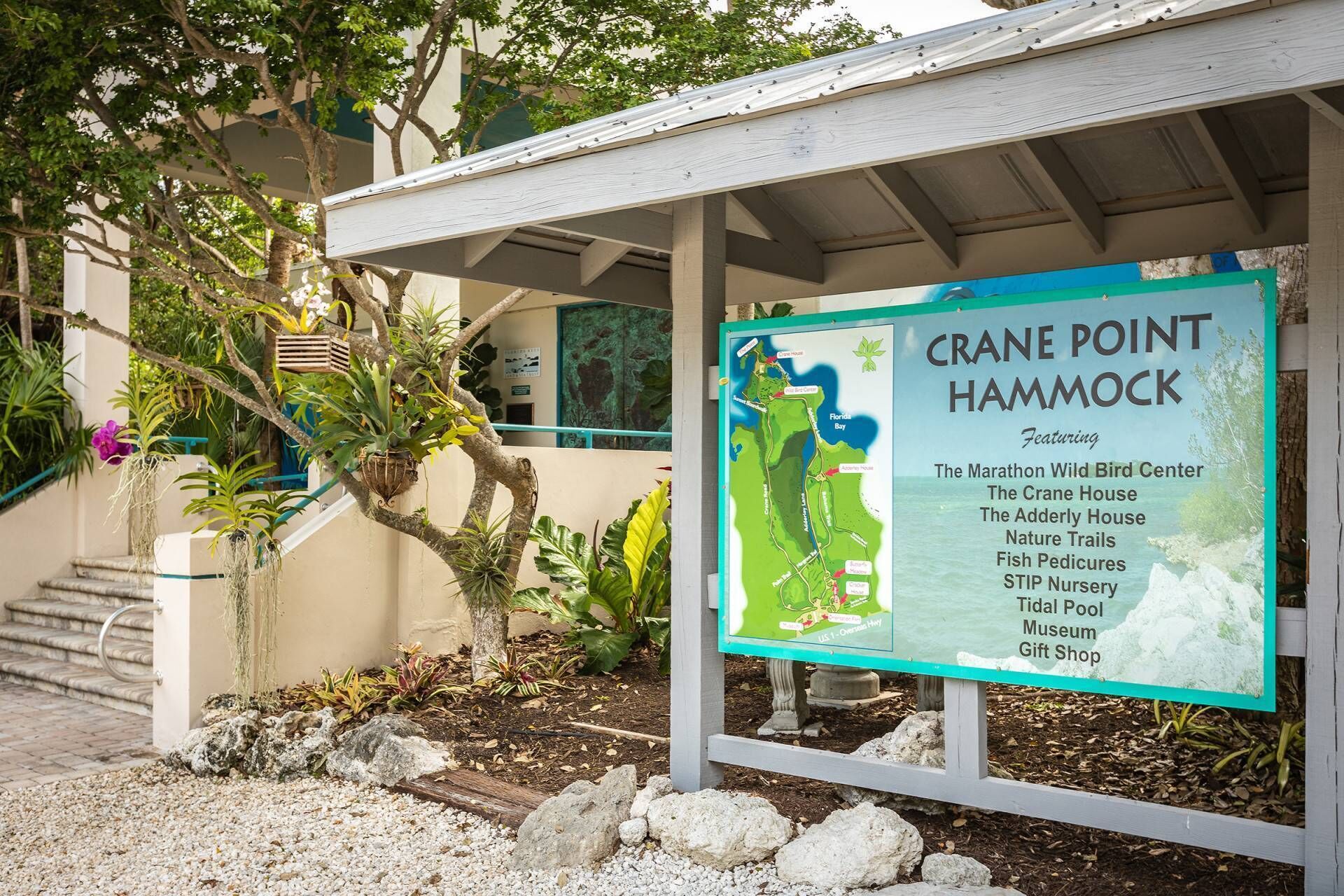 Un panneau indiquant l’accès à Crane Point Hammock, avec une liste des attractions, notamment le Marathon Wild Bird Center et la Crane House.