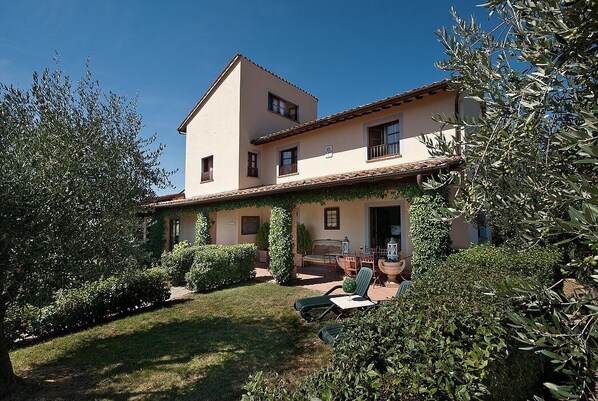 A two-story house with a covered patio and outdoor seating area.