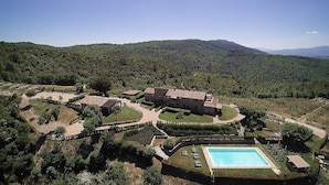 A large building with multiple wings, surrounded by landscaped gardens and a swimming pool. - Villa Sonia M: A characteristic and welcoming cottage located in an isolated position, on the slopes of a hill which is covered with olive groves, with Free WI-FI. (Gualdo Cattaneo)