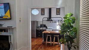 Een moderne keuken met een houten eiland, zwarte apparaten en een hanglamp.