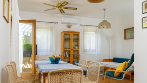 Un espace repas comprenant une table, des chaises et un ventilateur de plafond.