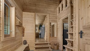 Een houten interieur met een trap die leidt naar een keukenhoek.