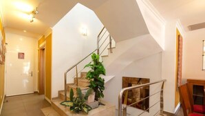 A spacious living area with a staircase, a fireplace, and a dining area with a red chair. - Vacation home Ni Hao by Interhome (Calpe/Calp)