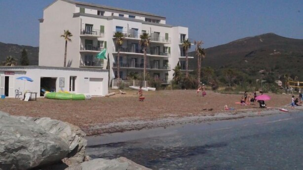 A multi-story hotel with balconies, a beach in the foreground, and mountains in the background. - T2 vue baie by Interhome (Macinaggio)