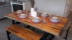 A dining table set with plates, bowls, glasses, and cutlery. - Relaxing home w/king suite in South Anchorage! (Anchorage)