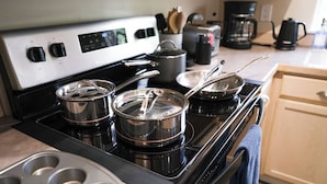 A kitchen with a stove, pots, and a coffee maker. - Relaxing home w/king suite in South Anchorage! (Anchorage)