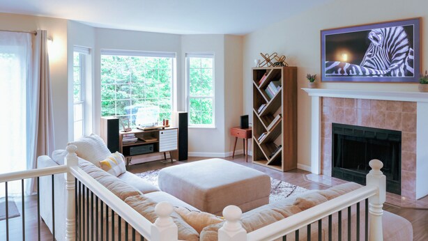 A living room with a fireplace, a sofa, a TV, and a bookshelf. - Relaxing home w/king suite in South Anchorage! (Anchorage)