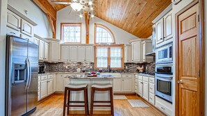 Una cocina amplia con techos altos, vigas de madera y ventanas grandes.