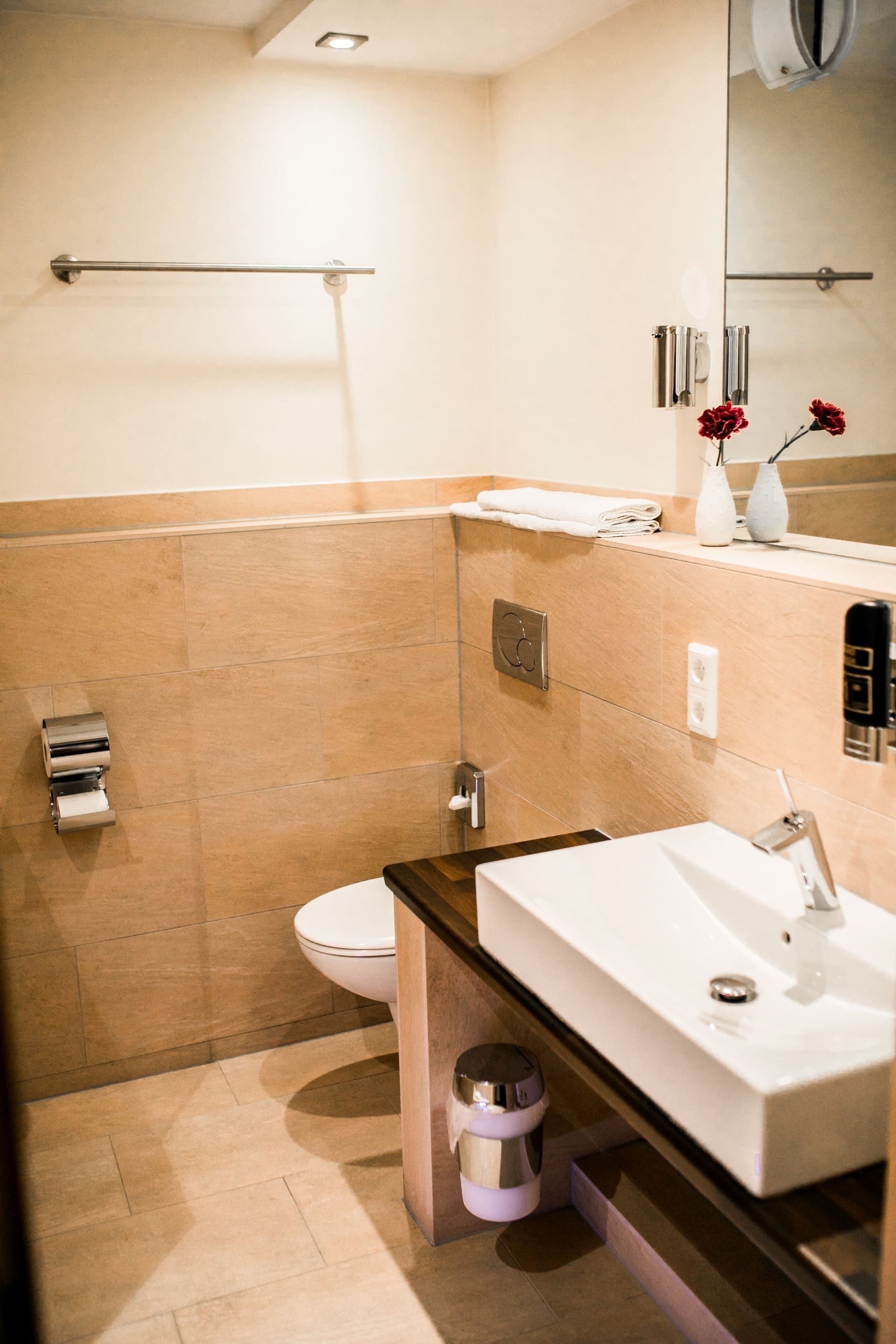 Ein modernes Badezimmer mit Toilette, Waschbecken und Spiegel.