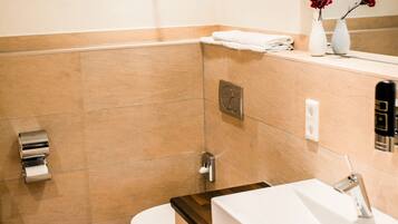 Ein modernes Badezimmer mit Toilette, Waschbecken und Spiegel.