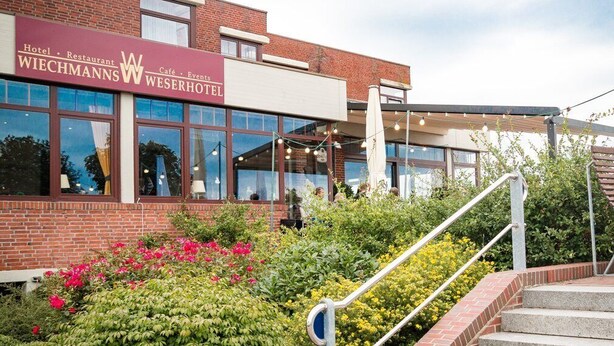 A hotel with a prominent sign for 'WIECHMANN'S HOTEL' and 'Café & Events'. - Wiechmanns Weserhotel (Brake)
