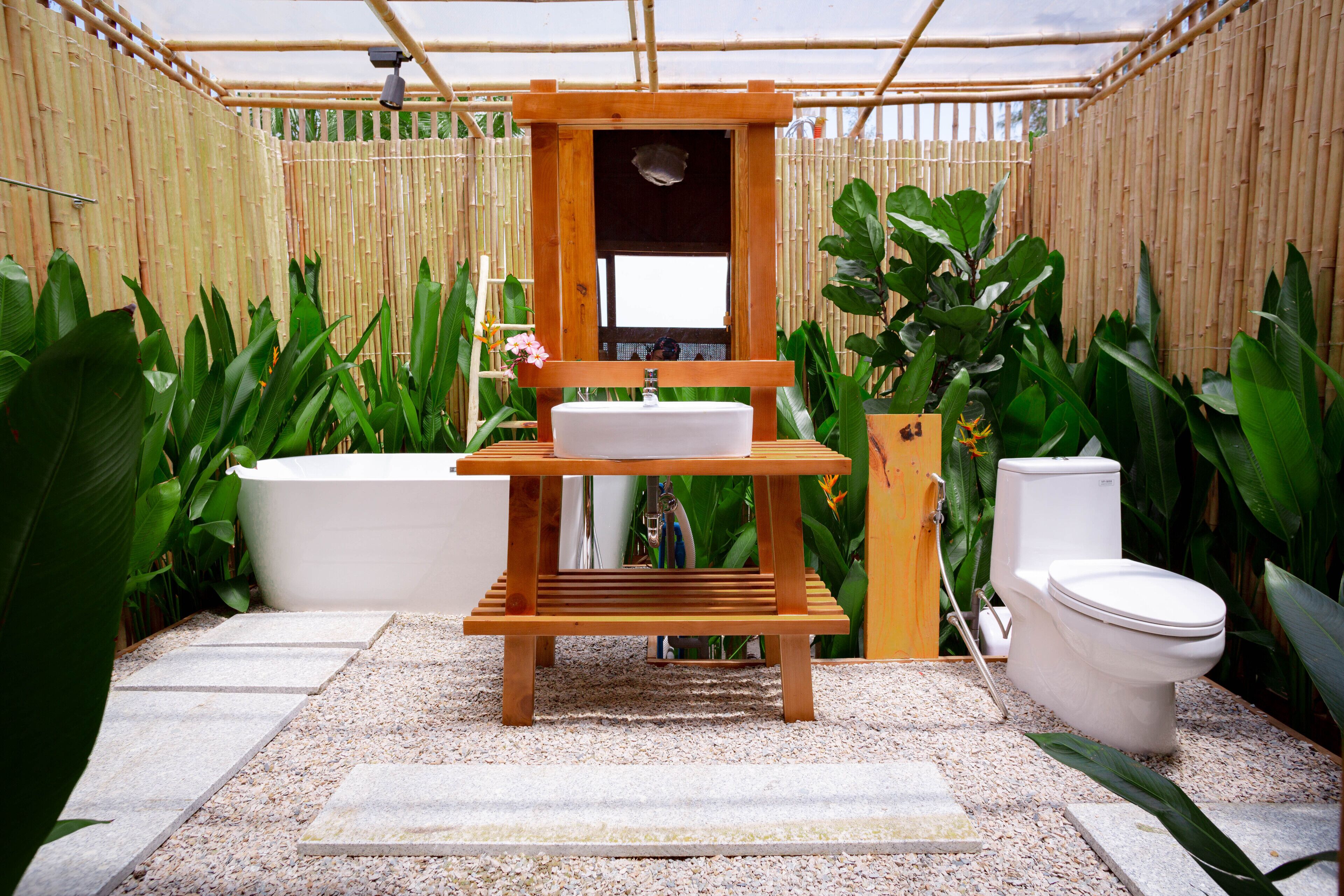 A bathroom with a wooden vanity, a white sink, and a toilet.