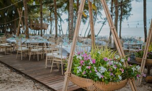 A beachside outdoor dining area with bamboo structures and tables set up for guests. - Hola Beach-Beach Club & Eco Glamping Resort (Tan Thanh)