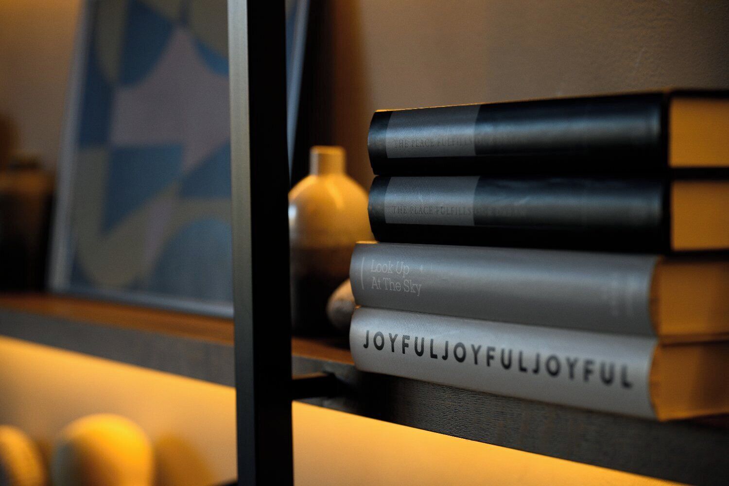 A stack of books with the title 'JOYFULJOYFULJOYFULJOYFUL' on a shelf.