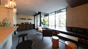 A modern interior with a bar area, seating, and large windows. - BROOKLYN HOTEL (Sapporo)