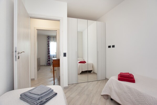 A hotel room with a bed, a desk, a wardrobe, and a bathroom. - Casa Michela Holiday Home with Mountain View, Garden, and Wi-Fi (Padru)