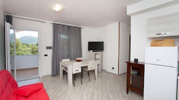 Een knus woongedeelte met een eethoek, een televisie en een kitchenette.