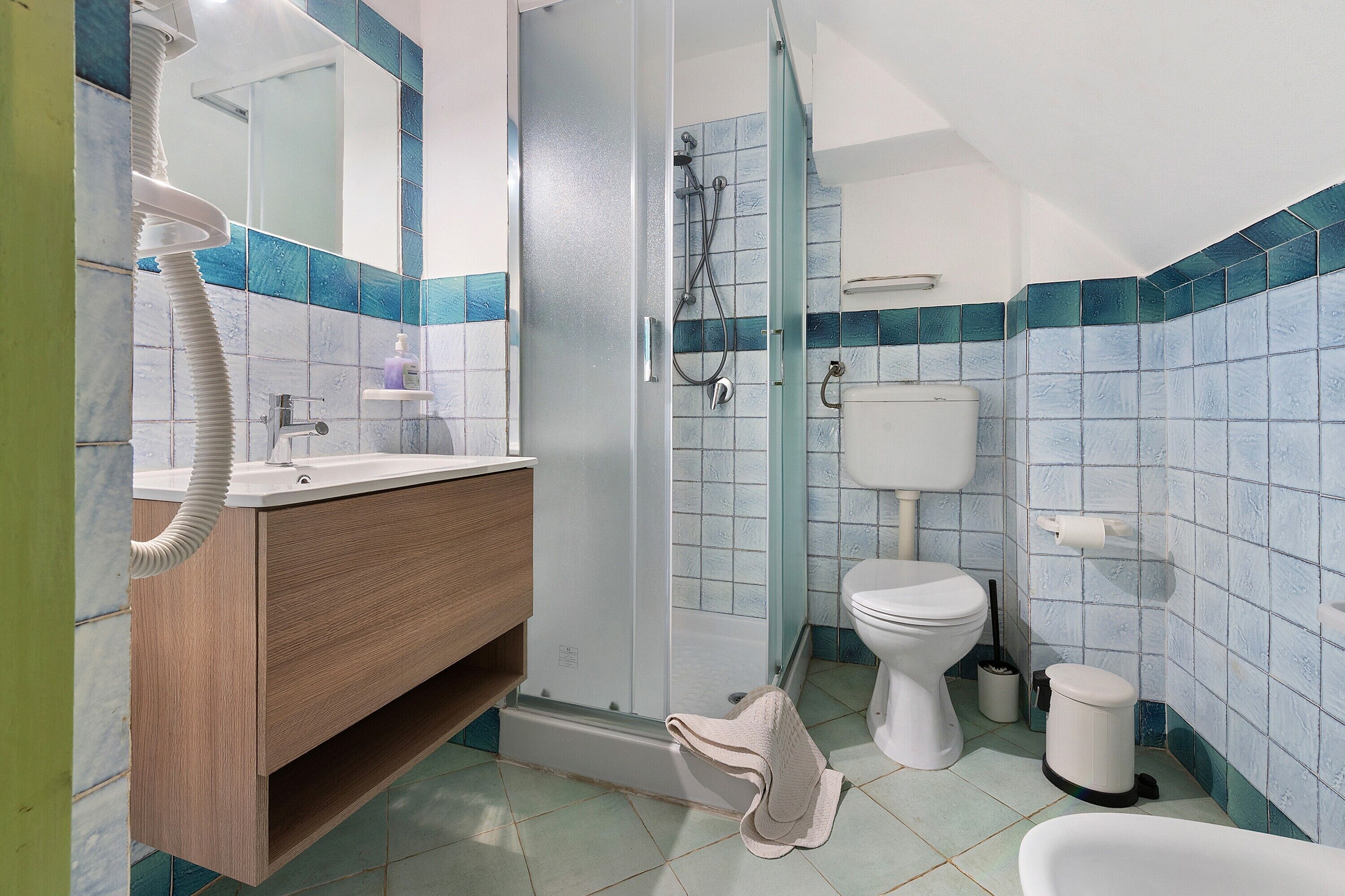 A bathroom with a shower, toilet, and sink.