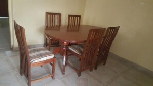 A dining table with four wooden chairs, each with a cushioned seat.