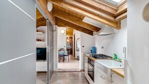 Una cocina con tragaluces, vigas de madera, estufa y refrigerador.